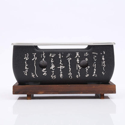 Black ceramic pot with white text on a wooden stand against a white background